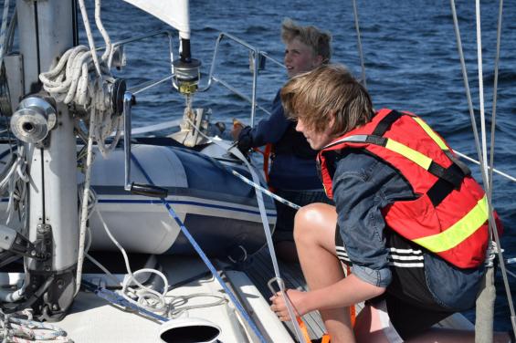 När vindstyrkan närmar sig 10 meter per sekund passar vi på att öva att ta sig från aktern till fören och åter till aktern på andra sidan med  kopplad livlina. Vårt band från ankarrullen går från akter till för och åter. Nyttig övning under realistiska förhållanden.