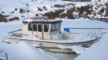 Av bilden att döma har ägaren till denna Targa värme i båten. Vatten kan skymtas runt skrovet. Om värmaren fungerat hela vintern är det troligt att ägaren kan starta motorn och köra iväg när isen gått. Dock bör man vara extra uppmärksam nu på våren. Det kan finnas dålda frostsprängningar i både motor och genomföringar.