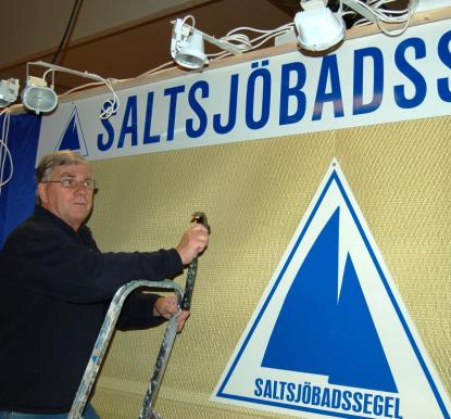 Många av de kända segelloften är på plats. Här använder, för ovanlighetens skull, Stig Nilsson från Saltsjöbadssegel, en hammare i kombination med segelduk. Men till öppningen har han spikat färdigt.