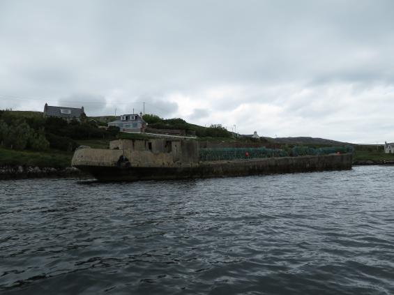 Detta fartyg i ferrocement lär ska ha legat här sedan kriget. Nu används det som kaj för fiskebåtar i en vik utanför Tarbert.